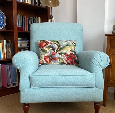 Sillón orejero tapizado en loneta azul celeste conservando patas con ruedas originales. Tenerife