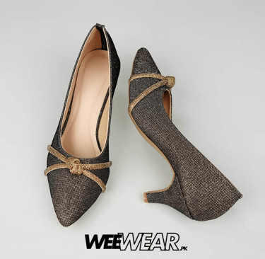 a pair of shoes with a gold buckle on the heel