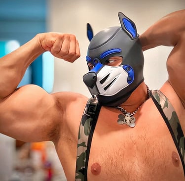 A man fleses while posing in his pup mask.
