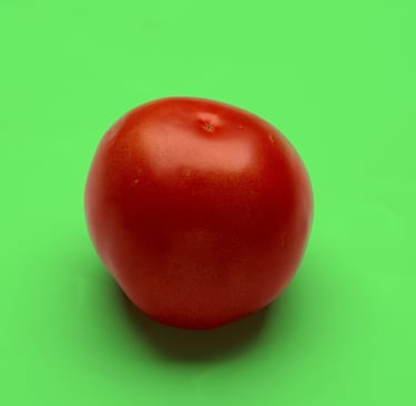 a ripe red tomato on a green color background