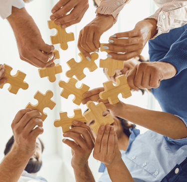 a group of people holding puzzle pieces
