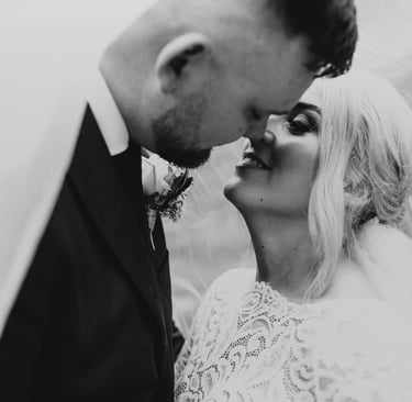 a bride and groom kissing in a black and white photo