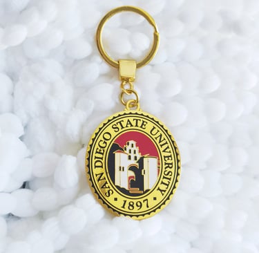 a gold keychain of San Diego State University