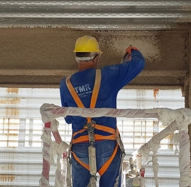 Homem Aplicando Argamassa Contra Fogo em Estrutura Metálica
