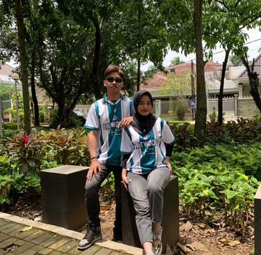 a man and woman sitting on a bench in a park