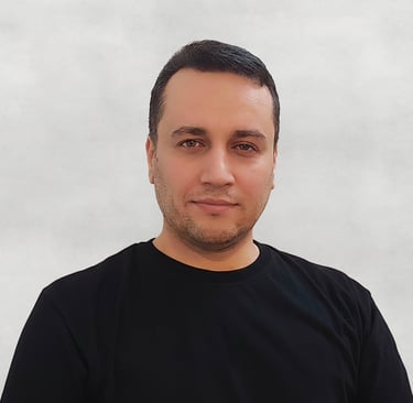 Portrait of a VISUALISE team member, black T-shirt, with a plain neutral background.