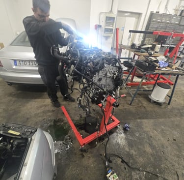 Motorenrevision: KFZ-Mechaniker bei der Arbeit an einem ausgebauten Motor.