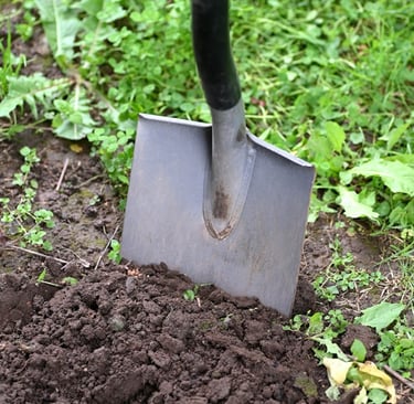 a person digging up soil with a showel
