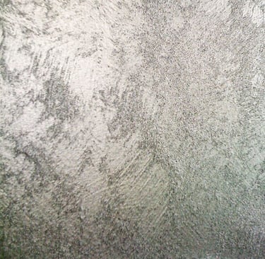 A cool silver paint sample showing off its shimmering grainy texture.