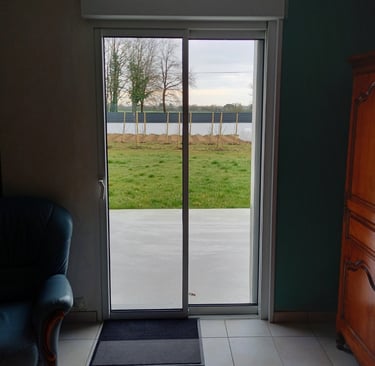 porte coulissante en pvc blanc donnant sur jardin posée par l'artisan menuisier en Vendée