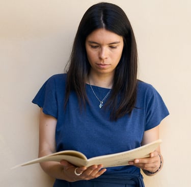 a woman in a blue dress is reading a book