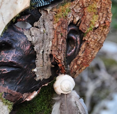 Masque d’écorce photographié en forêt, œuvre de Samuel Chazot