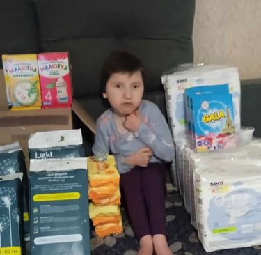 дівчинка сидить на дивані з великою кількістю підгузників