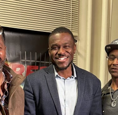 three men standing in a room with a guitar
