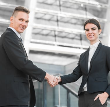 two men shaking hands in front of a building