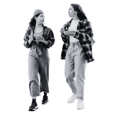 Two women walking with trays of food