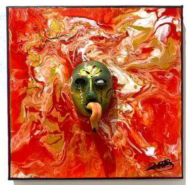 un visage sculpté vert avec une longue langue qui émerge d'un tableau rouge