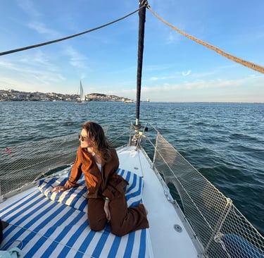 Pessoa sentada na ponta do barco, com a agua ao fundo
