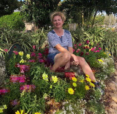 Melanie the owner sitting on a bench in a garden