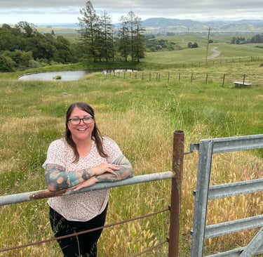 a woman standing in front of a fenced in area