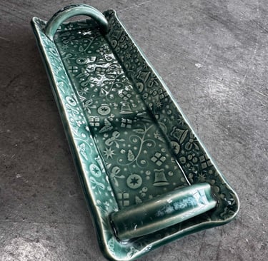 A handmade textured cracker tray with handles. 