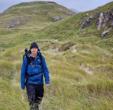 Martin Photography workshop tutor in grass carrying camera bag
