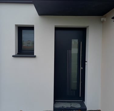 porte d'entrée en pvc noire et fenêtre en pvc noire sur maison neuve posée par l'artisan menuisier 