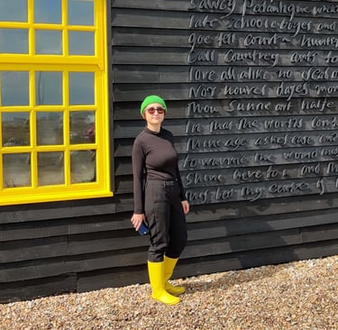 photo of Micha wearing bright yellow welly boots next to yellow window