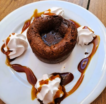 Coulant de chocolate que refleja la historia del Bar Las Tinajas Huelva, con presentación cuidada y sabor tradicional.