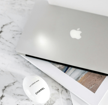Luxury workspace flat lay with laptop and Chanel cream