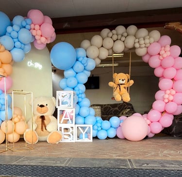 Decoración temática para fiesta de revelación de género con un arco de globos en colores pastel azul