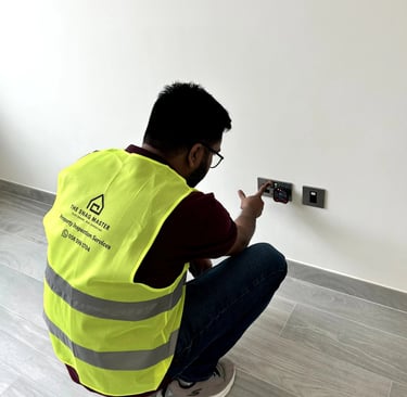 Engineer testing electrical socket for voltage and safety compliance during villa inspection