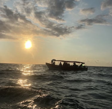 Una pequeña embarcación turística transportando pasajeros sobre las olas del océano durante un atard