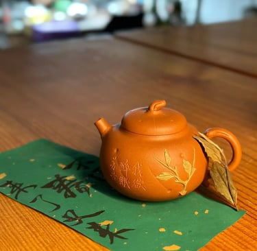 A brown teapot placed on green paper with text written on it