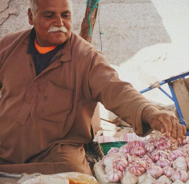 man in brown jacket selling spices in souk
