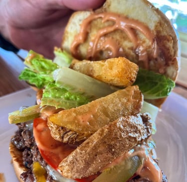 Burger with fresh ingredients and french fries at Barrel Bar & Grill restaurant