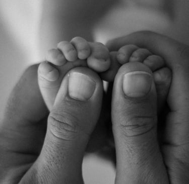 newborn feet in dads hands