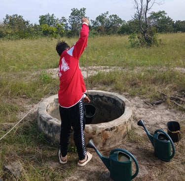 Photo d'un jeune accompagné par Bourokk et Kadiamor qui cherche l'eau dans le puit