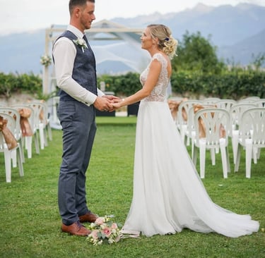 Photo d'un couple de mariés face à face se tenant la main sur le lieux de leur cérémonie de mariage