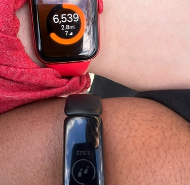 two people wearing a red and black watch on their wrist.