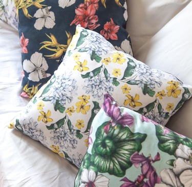 Four Pillows with multicolor hand-drawn floral patterns on a white couch