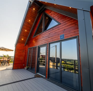 a wooden house with a large deck and a glass doors