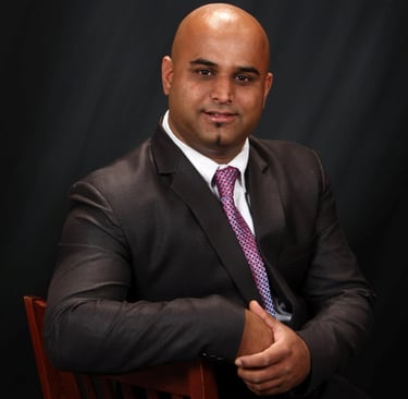 a man in a suit and tie sitting in a chair
