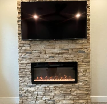 Wall-mounted TV above stone fireplace built by At Hand Heroes in Glendale AZ