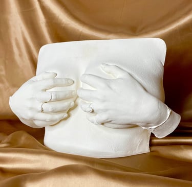 Moulage mains sur poitrine en plâtre sur fond doré