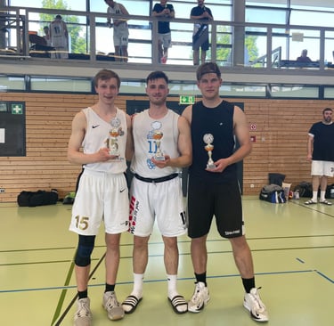 alt="Three basketball players displaying their individual trophies."