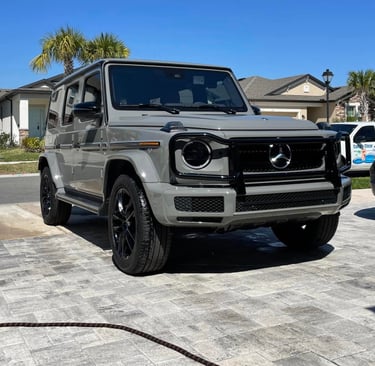 Gray Mercedes G-Wagon freshly detailed on a paver driveway in a sunny suburban neighborhood in tampa bay