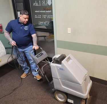 a man cleaning a carpet with a machine