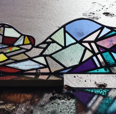 Full Sized Stained Glass Woman. Photograph is taken on a beach at low tide. Art work by Laura Kriefman