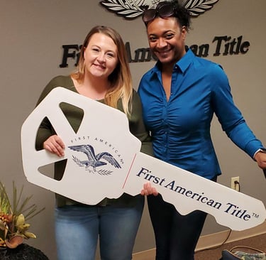 two women standing next to each other holding a sign